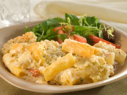 Baked Pasta and cheese alongside a salad on a light brown plate