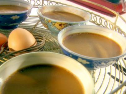 Cafe au lait pots de creme set on a serving tray with brown eggs in the middle of the tray.