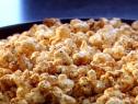 Neely's BBQ popcorn is seasoned with Neely's BBQ Seasoning, grated parmesan, melted butter, salt, and freshly ground black pepper.