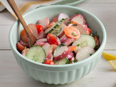 Potato salad in a light green bowl on a white washed tabletop