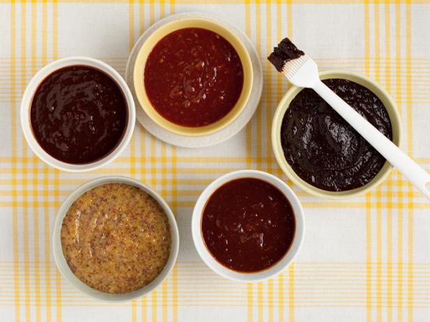 Five sauces in small dishes on a yellow and white plaid tablecloth