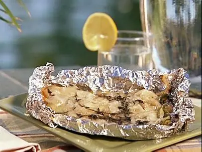 Scalloped zucchini in unwrapped aluminum foil placed on a square green plate