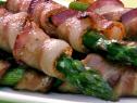 Asparagus wrapped in bacon and stacked on a plate