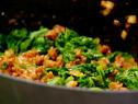 Greens are mixed with crumbles of cooked andouille sausage and onion.