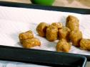 Fried homemade tater tots lay on a paper towel.