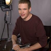 A studio shot of former NFNS rival Shane Lyons seated in a directors chair
