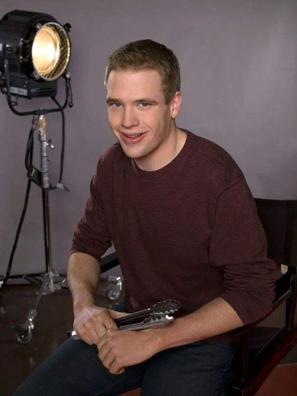 A studio shot of former NFNS rival Shane Lyons seated in a directors chair