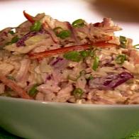 Coleslaw in a plain white bowl that is placed on a green place setting