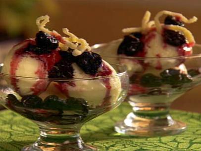 Scoops of vanilla ice cream topped with cherry sauce in glass dessert dishes