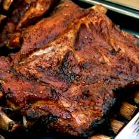 A close-up of a baking pan full of partial slabs of ribs