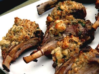 Grilled lamb chops encrusted with bread crumbs and gorgonzola on a simple white plate