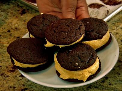 Five chocolate cookies with a thick pumpkin filling placed on a small simple white plate