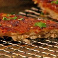 Potato wedges sprinkled with chopped parsley leaves on a cooling rack