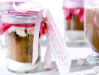 Hot chocolate jars are filled with cocoa powder, sugar, cinnamon, and marshmallows.
