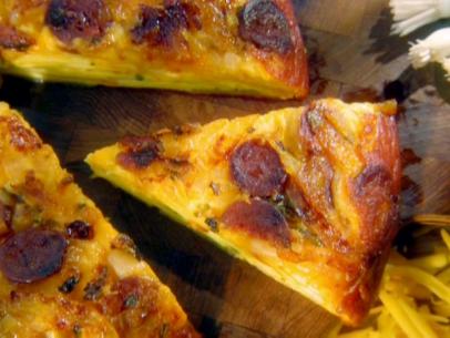 Slices of spanish tortilla made with shredded cheese, chorizo, garlic, onion, and potatoes.
