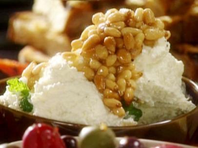 Antipasto platter with honey toasted pine nuts poured over the top of a ricotta spread with fresh mint leaves.