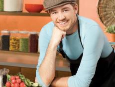 Next Food Network Star Finalist Brad Sorenson smiling while wearing a light blue shirt and black apron