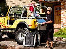 Guy Fieri and his son packing a yellow jeep with a cooler and chairs