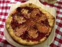 A pizza is served on a wooden board.