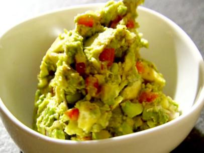 Guacamole is made with ripe avocados, freshly squeezed lemon juice, minced garlic, kosher salt, black pepper, tomato, and red onion.
