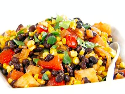 Black bean, corn, and tomato salad is served with chopped cilantro on top.