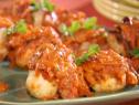 Grilled wahoo fillets are topped with a tomato sauce and chopped herbs.