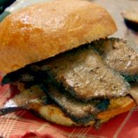 Slices of braised beef brisket is served on a roll.
