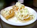 La Fondita fish tacos are made with tortilla shells, chipotle mayonnaise, codfish, and topped with shredded cabbage.