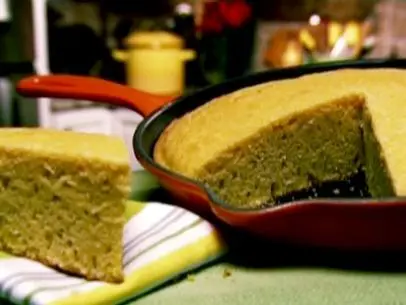 A piece of Gina's crusty cornbread has been cut from the skillet and placed on a towel.
