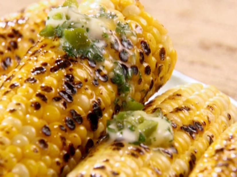 Grilled ears of corn are topped with a jalapeno butter.
