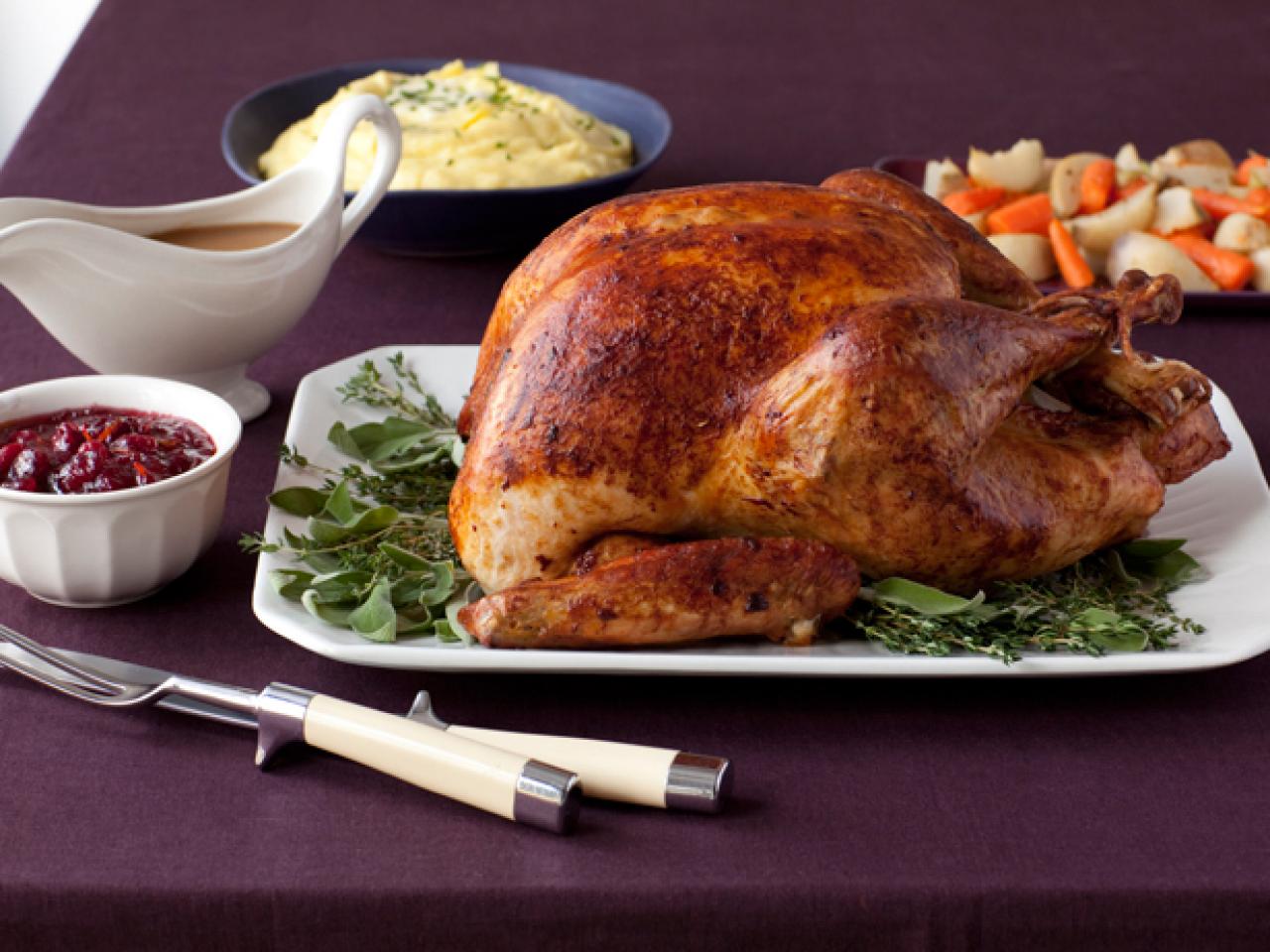 Young and matue men holding tray with homemade roasted turkey over