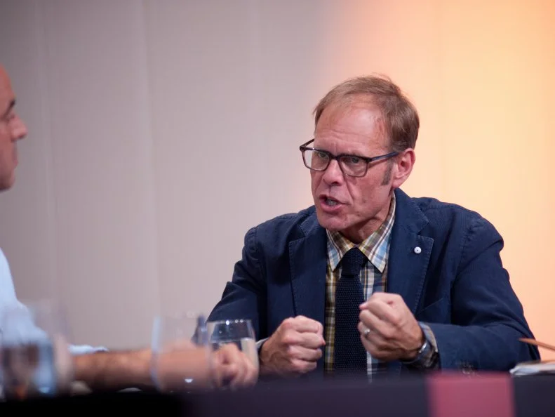 Host Alton Brown tasting Rival-Chef's dishes at Judges Table in Episode 7 Chairman's Challenge "Passion" as seen on Food Network Next Iron Chef Season 4.