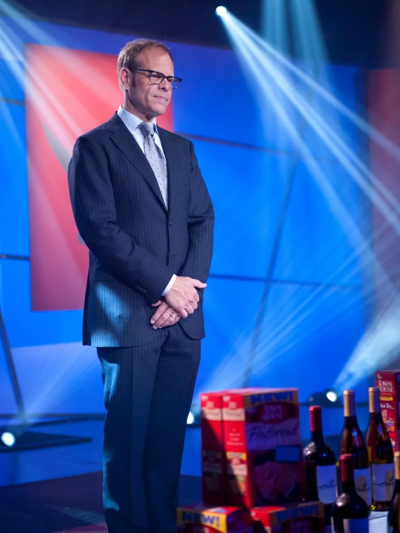 Host Alton Brown revealing the Secret Ingredient in Episode 7 Secret Ingredient "Keebler Town House Crackers & Wine" Showdown as seen on Food Network Next Iron Chef Season 4.