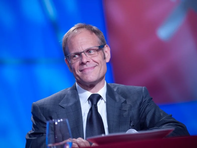 Host Alton Brown tasting Rival-Chef Elizabeth Falkners dishes in Episode 8 Finale Battle "Holiday Extravaganza" as seen on Food Network Next Iron Chef Season 4.