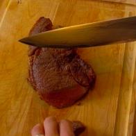The sirloin is sliced on the cutting board.