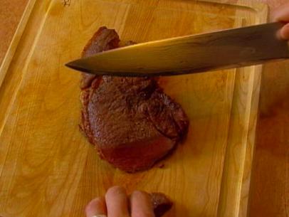 The sirloin is sliced on the cutting board.