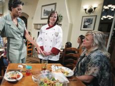 First Lady Michelle Obama, accompanied by Darden chef Julie Elkinton, talks to Charisse McElroy, right, and her daughter Jacqueline McElroy, 9, during an event at Olive Garden in Hyattsville, Md. on Thursday.