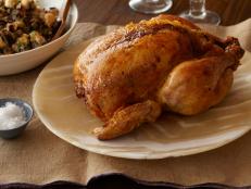 This wild rice dressing is lighter than a bread-based version and packed with earthy fried fruit. A fruit preserve and cider vinegar glaze on the roast chicken makes the skin extra crispy and flavorful.
