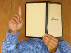 Man holding menu and raising hand