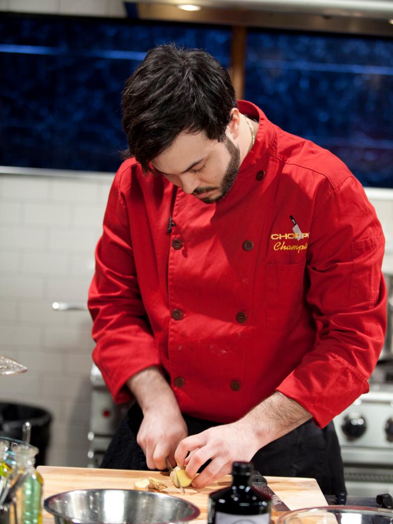Chef Corwin Kaye slices ginger root, as seen on Food Network’s Chopped Champions, Season 14.