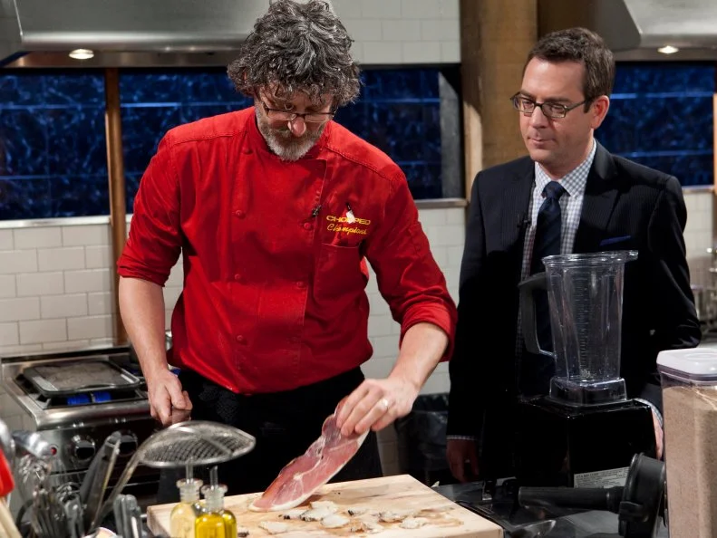 Chopped Host Ted Allen talking to Chopped Champion Chef Rob Evans about his entree that must include: Abalone, curry leaves, amaranth grain and Serrano Ham, as seen on Food Networks Chopped, Season 14