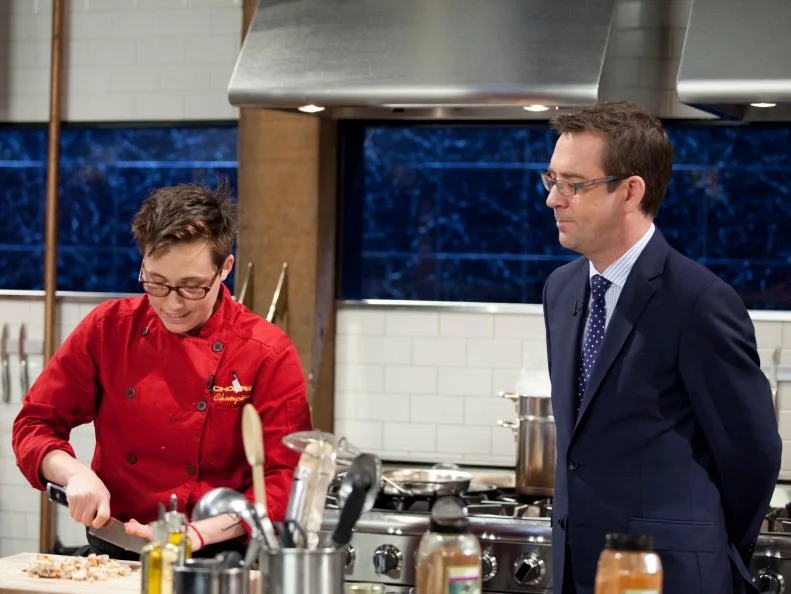 Host Ted Allen checks in with Chef Elise Komack, as seen on Food Network’s Chopped Champions, Season 14.