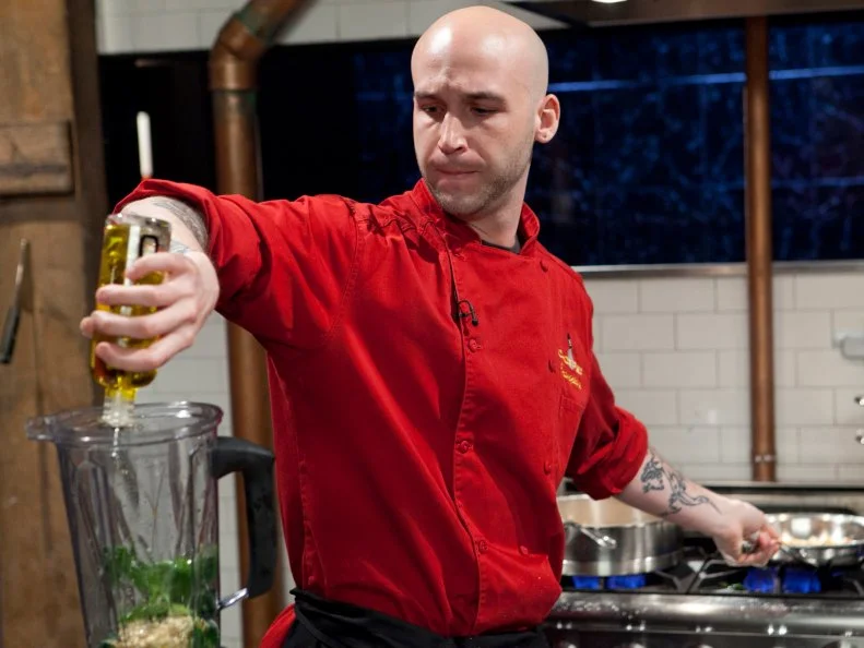 Chopped Champion Chef Vinson Petrillo working on his appetizer which must include: pig ears, ramps, pine nuts and apple strudel, as seen on Food Networks Chopped, Season 14.