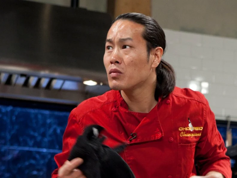 Chopped Champion Chef Jun Tanaka working on his appetizer which must include: pig ears, ramps, pine nuts and apple strudel, as seen on Food Networks Chopped, Season 14.