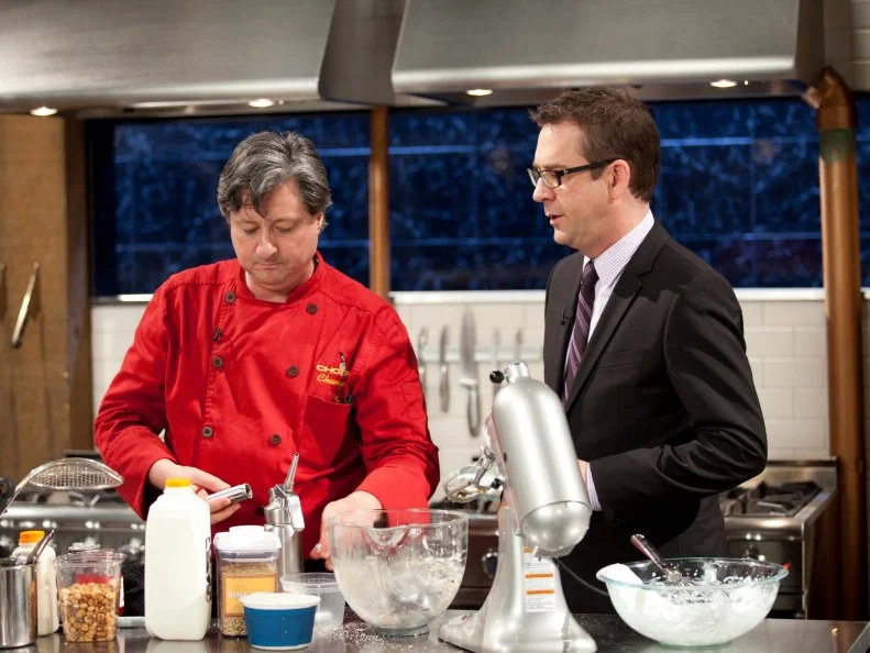Host Ted Allen checks in with Chef Jean-Louis Gerin, as seen on Food Network’s Chopped Champions, Season 14.