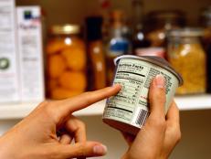 Person Reading Nutrition Label on Packaged Food