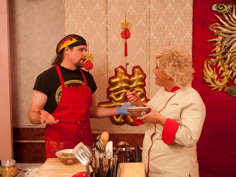 Red Team Leader Chef Anne Burrell tastes noodles prepared by Red Team Recruit Robert Tamke for the "Chinese Noodle Pulling" skill drill as seen on Food Network's Worst Cooks in America, Season 3.