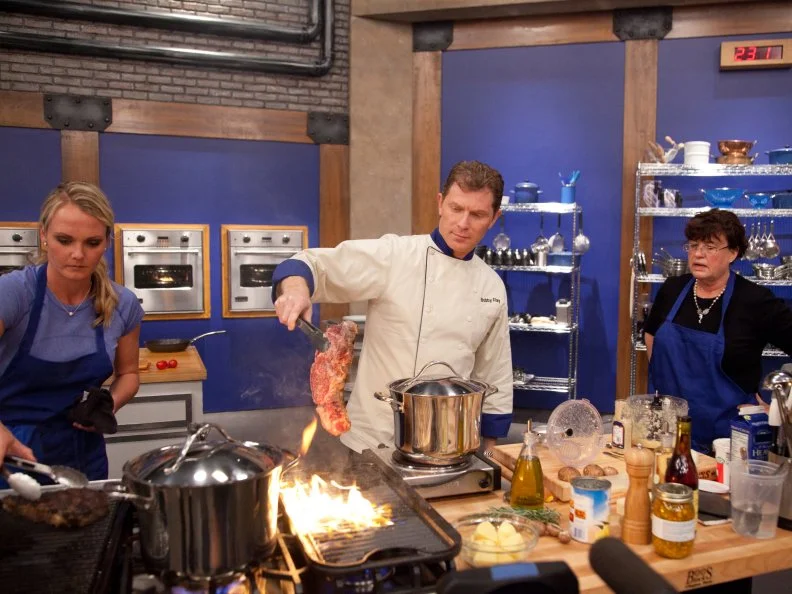 Chef Bobby Flay helps Blue Team Recruit Erica Weidner after her  "False Alarm!" steak set fire.  The dish is being prepared for the Extreme Flavor Challenge" as seen on Food Network's Worst Cooks in America, Season 3.