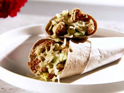 A plate of chicken wraps with sweet mustard.