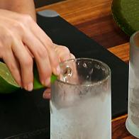 A lime is rubbed around the rim of a frosted mug.